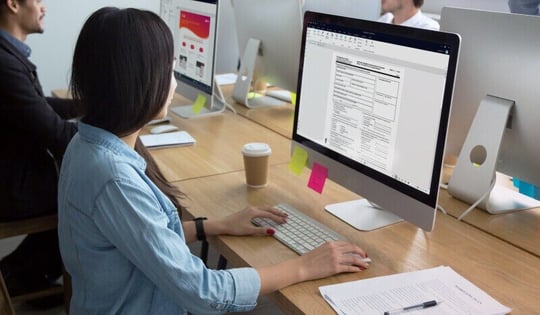 Woman working on a desktop computer in a shared office space