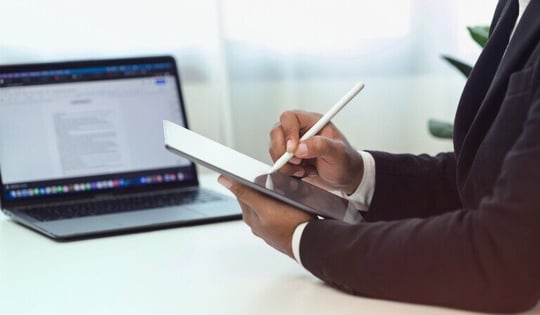 Professional man writing on a tablet in the office